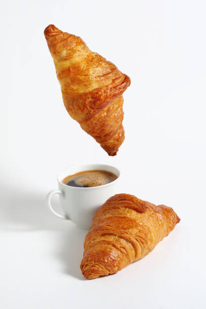 istock Croissant hanging over coffee 2155002980