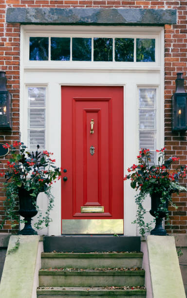 istock A bright red front door with cream trim and a transom with front steps on a red brick house building 2155003323