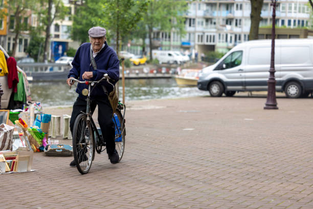 Netherlands, Amsterdam-May 24,2024: People using bicycles for transportation in Amsterdam. Cycling in Amsterdam allows you to access popular attractions, parks, and neighborhoods with ease