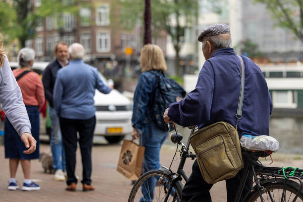 Netherlands, Amsterdam-May 24,2024: People using bicycles for transportation in Amsterdam. Cycling in Amsterdam allows you to access popular attractions, parks, and neighborhoods with ease