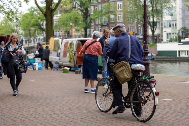 Netherlands, Amsterdam-May 24,2024: People using bicycles for transportation in Amsterdam. Cycling in Amsterdam allows you to access popular attractions, parks, and neighborhoods with ease