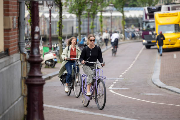 Netherlands, Amsterdam-May 24,2024: People using bicycles for transportation in Amsterdam. Cycling in Amsterdam allows you to access popular attractions, parks, and neighborhoods with ease