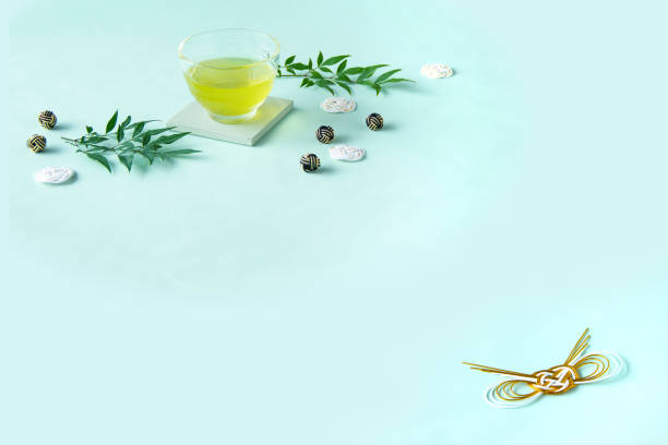 cold  green tea and mizuhiki and Nandina domestica with pale green background. Japanese style.