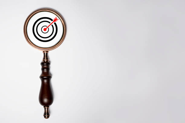 Target board inside of vintage magnifier glass for focus business objective on white background and copy space.