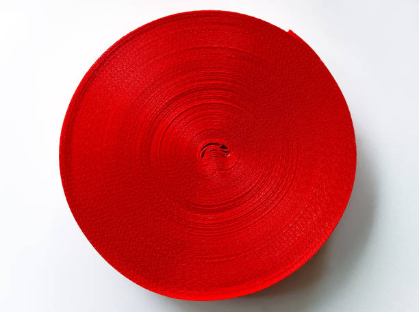 roll of thick and curly red satin ribbon isolated on a white background. coarse textured ribbon.