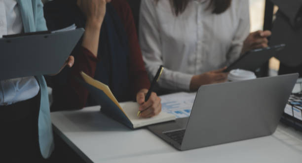 istock Financial analysts analyze business financial reports on a digital tablet planning investment project during a discussion at a meeting of corporate showing the results of their successful teamwork. 2155025410