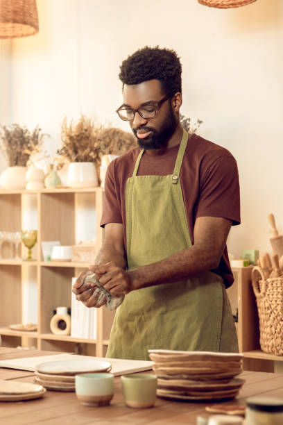 istock African american sculptor working with clay and looking involved 2155026027