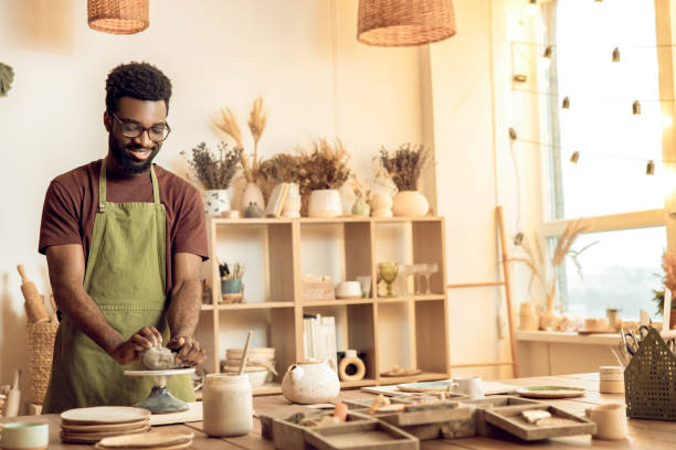 istock Dark-skinned sculptor molding clay in his hands 2155026035