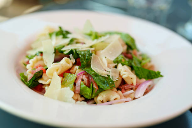 Fresh Summer Pasta and Lettuce Parmesan Salad - Crispy Romaine lettuce with pasta and fresh sliced Salami, Parmesan Cheese, tomatoes, and red onion.
