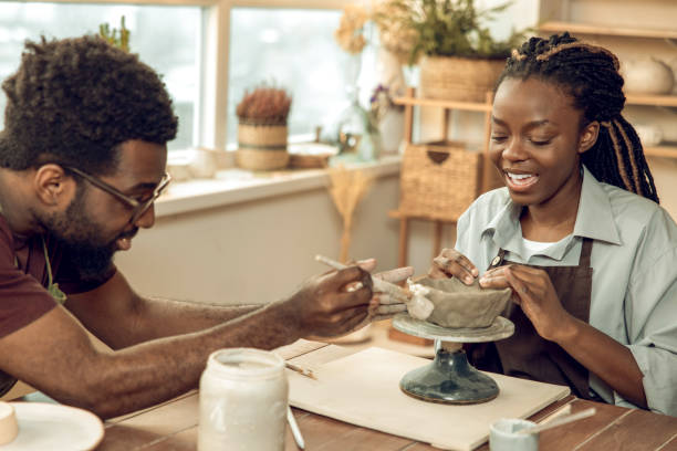 istock Cute dark-skinned woman having a pottery master class with a male sculptor 2155026349