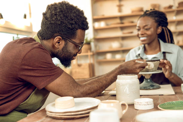 istock Two people working with pottery and looking involved 2155026358