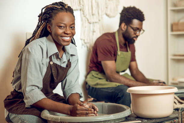 istock Sculptors working with pottery wheel and looking contented 2155026475
