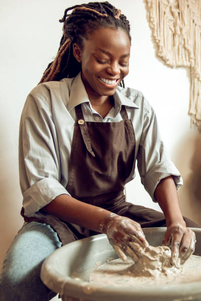 istock Smiling woman working on a pottery wheel and looking enjoyed 2155026541
