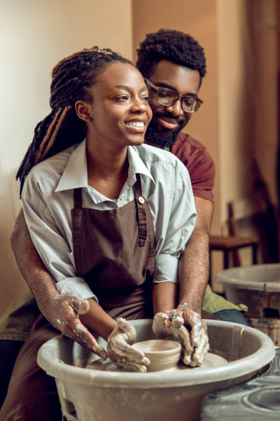istock Happy couple smiling and looking inspired working on a pottery wheel 2155026586