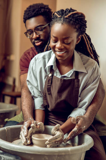 istock Happy couple smiling and looking inspired working on a pottery wheel 2155026589