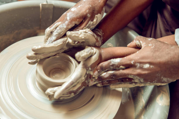 istock Hands of two people making a new pottery product together 2155026603