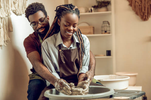 istock Happy couple smiling and looking inspired working on a pottery wheel 2155026605