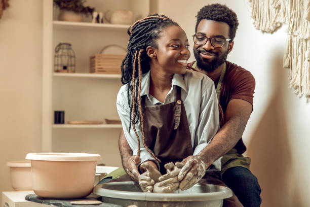 istock Happy couple smiling and looking inspired working on a pottery wheel 2155026607