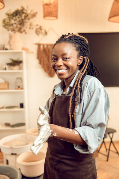istock Smiling young woman with a new clay mug in hands 2155026647
