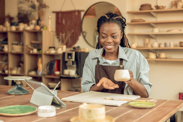 istock Cute smiling young woman holding a ceramic mug in hands 2155026780
