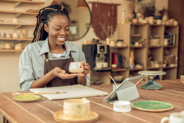 istock Cute smiling young woman holding a ceramic mug in hands 2155026784