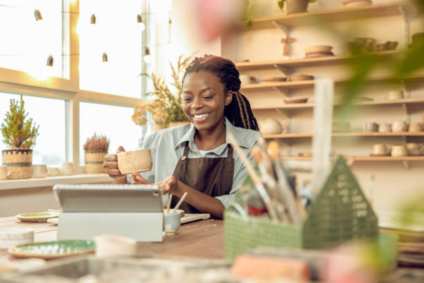 istock Cute smiling young woman holding a ceramic mug in hands 2155026798