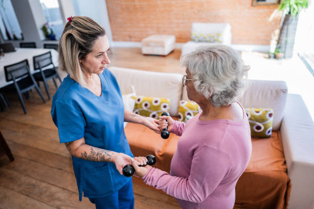 istock Physical therapist helping senior woman exercising with weights 2155027734