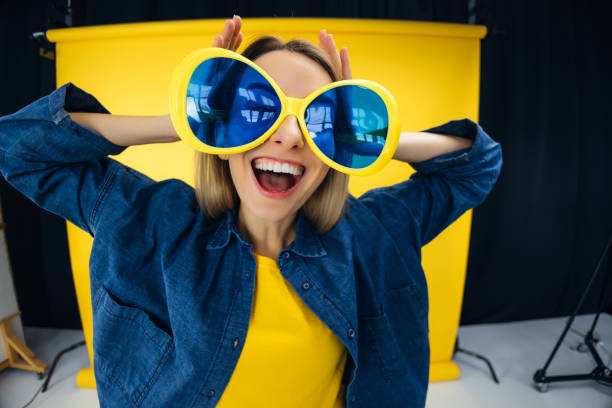 sweet shiny lady in party glasses dancing ein studio wide shot