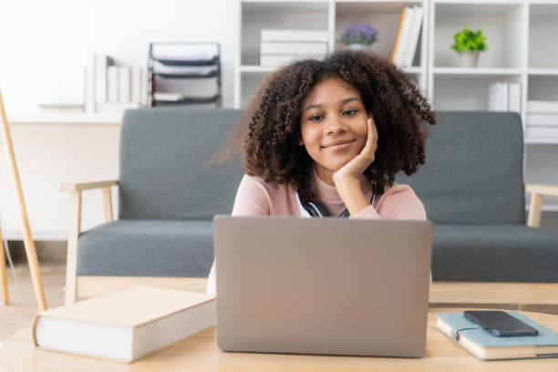 istock Happy young woman using laptop sitting at desk writing notes while watching webinar. Study online. Look at web learning or have online meeting, distance learning concept. 2155032137