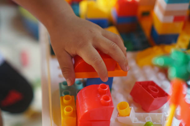 Children's hands assembling blocks to build a toy. In the development of small hand muscles. Select Focus.