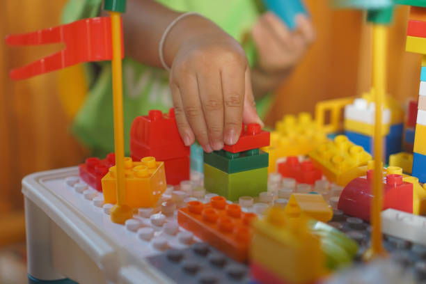 istock Children's hands assembling blocks to build a toy. In the development of small hand muscles. Select Focus. 2155034064