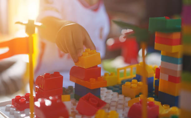 istock Children's hands assembling blocks to build a toy. In the development of small hand muscles. Select Focus. 2155034082