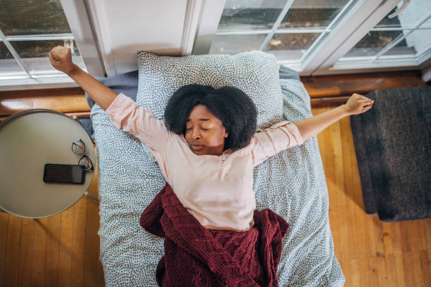 istock Woman stretching in bed, feeling refreshed 2155035238