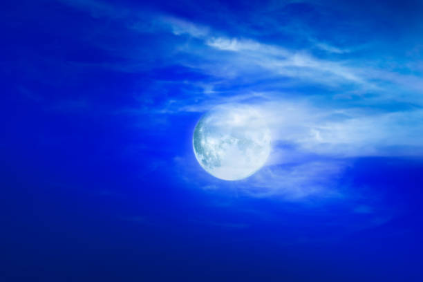 Moon and clouds in blue night sky