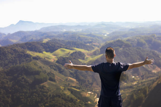istock A man enjoys a quiet moment in nature, standing with open arms. 2155038399