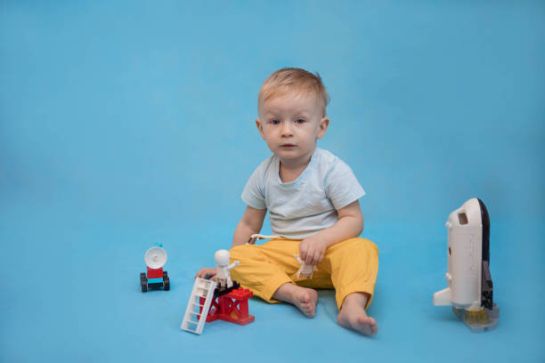 Cheerful child boy with construction set over blue background. Copy space.