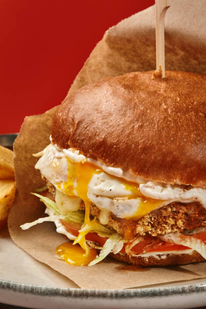 istock Hamburger with breaded patty and fried sunny side up egg 2155039943