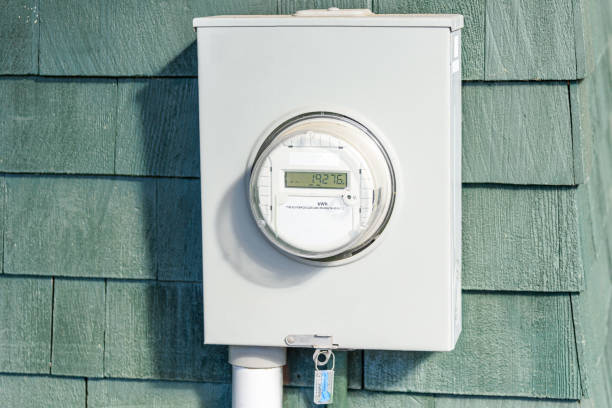 Close up of a smart electricity meter on a wooden external wall of a house on a sunny day
