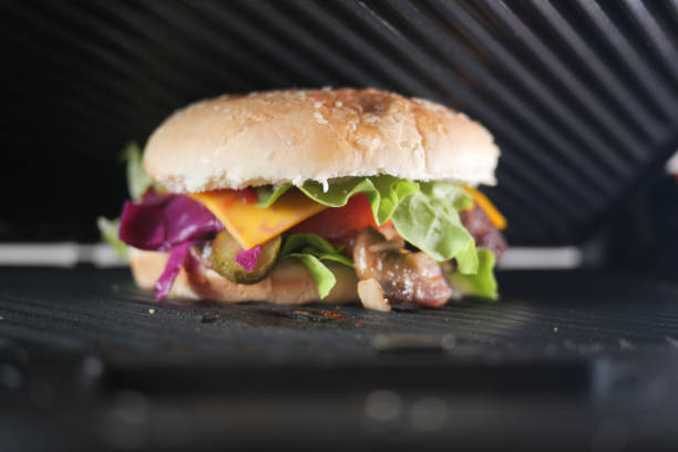 Sandwich with meatballs, lettuce, and red cabbage grilling.