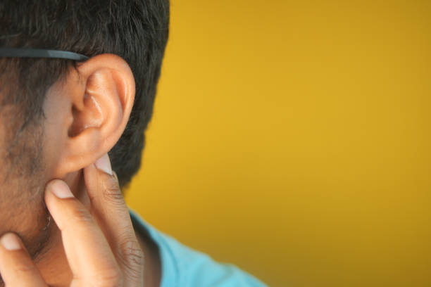 istock young man having ear pain touching his painful ear , 2155047116