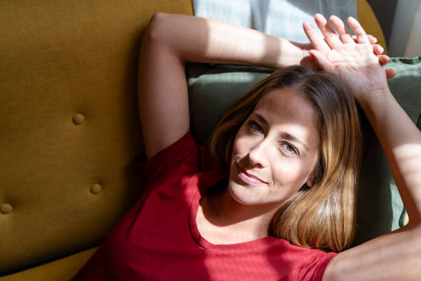 istock Woman enjoying natural light as she relaxes on a sofa 2155048434