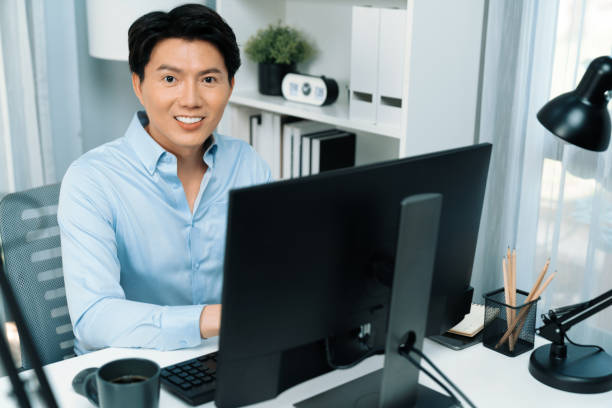 istock Portrait businessman looking camera to pose while working on computer. Infobahn. 2155050317