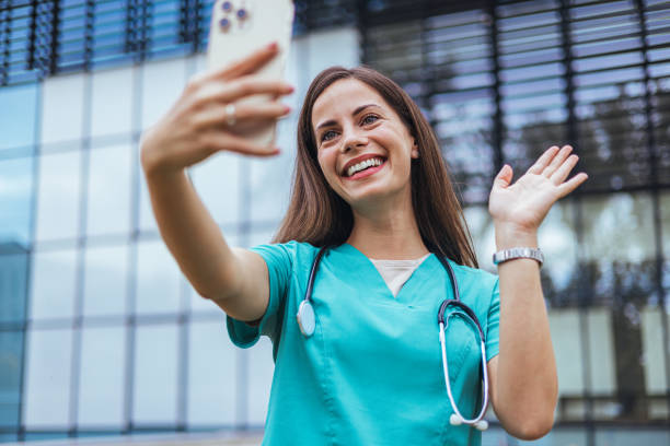 istock Smiling Caucasian Nurse with Smartphone 2155050468