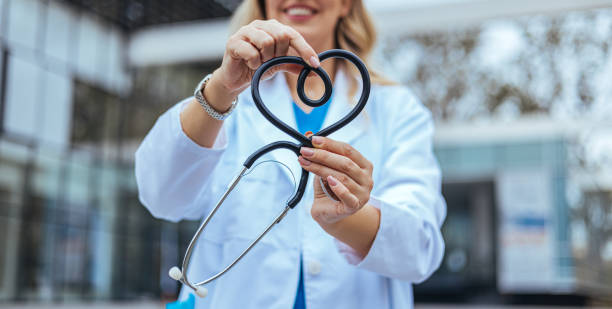 istock Smiling Nurse Holding a Heart-Shaped Stethoscope 2155050575