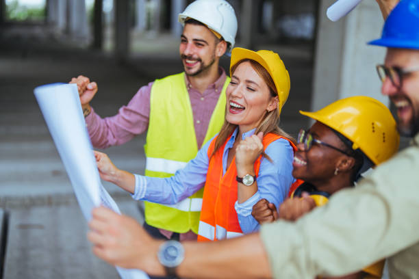 istock Smiling Diverse Team of Construction Workers Examining Building Plans 2155051340
