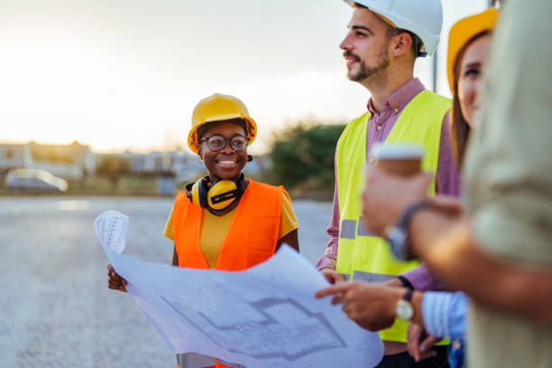 istock Diverse Team Reviews Construction Blueprint on Site 2155051428