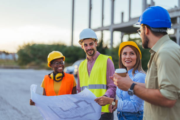 istock Diverse Team Reviews Plans at Construction Site 2155051440