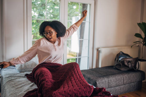 istock Woman stretching joyfully in her bed 2155052308