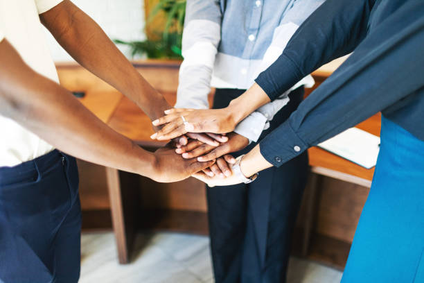 istock Business team putting hands together at the office 2155053772
