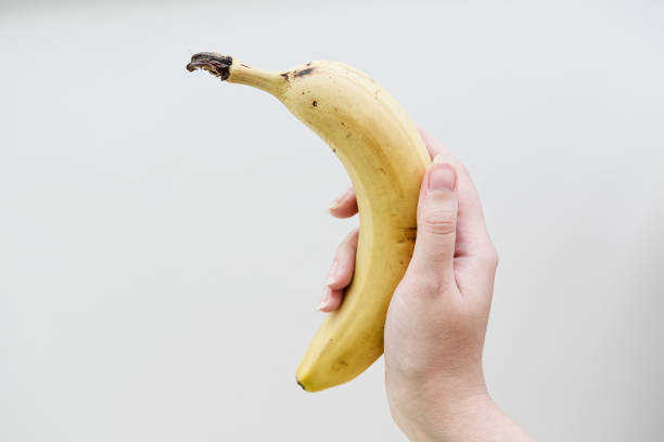 istock Woman's hand holding banana fruit. 2155055062